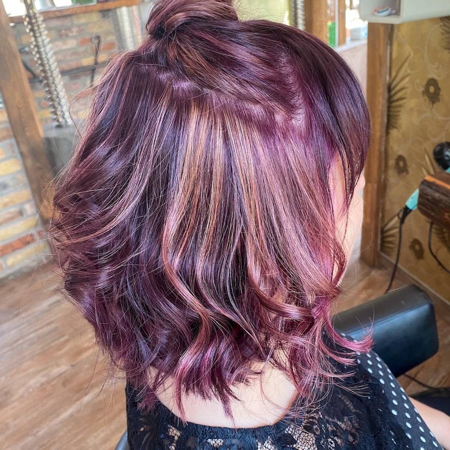 Mobiler Friseur in der Nähe: Kreative Haarfarbe mit violetten und kupferfarbenen Akzenten in welligem Bob – individuelles Farbspiel als Teil der professionellen Färbetechniken von Astrid Hornischer in Teuchern, Weißenfels, Naumburg und Zeitz.