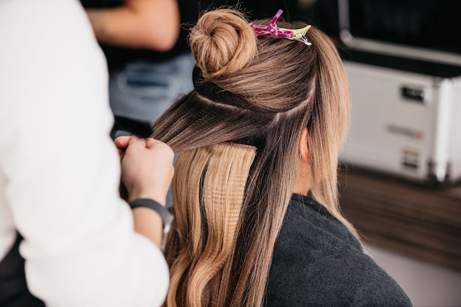 Mobiler Friseur in der Nähe: Anbringen von Haarverlängerungen bei einer Kundin – professionelle Echthaarverlängerung als Teil der mobilen Friseurdienstleistungen von Astrid Hornischer in Teuchern, Weißenfels, Naumburg und Zeitz.